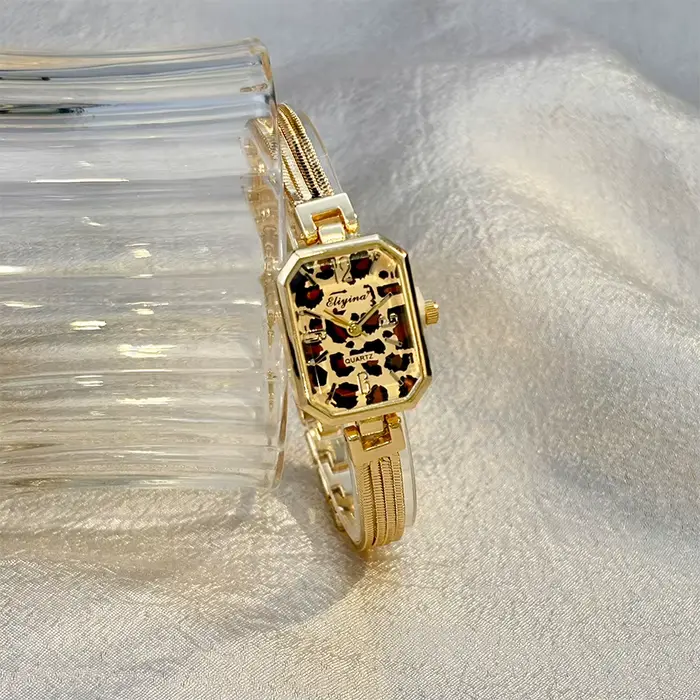 Montre-bracelet rectangulaire dorée pour femme avec chaînes à pampilles
