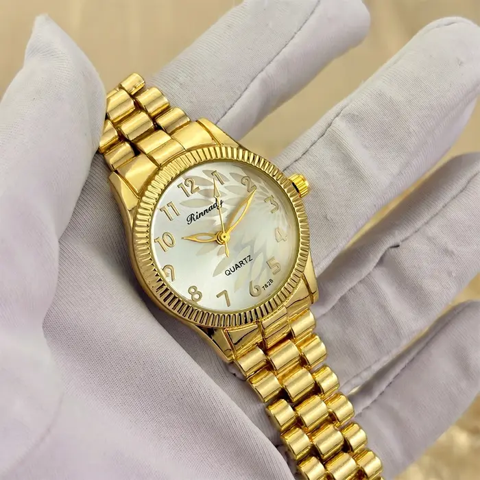 Montre classique élégante pour femme avec cadran à motif plume sur un côté