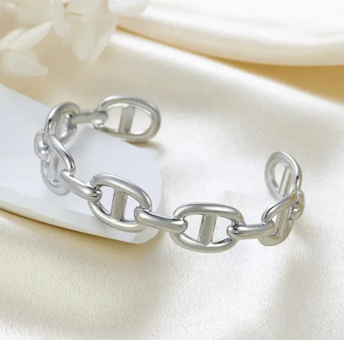 Bracelet ouvert en forme de C en titane et acier plaqué or 2026. Un accessoire unique, irrégulièreme