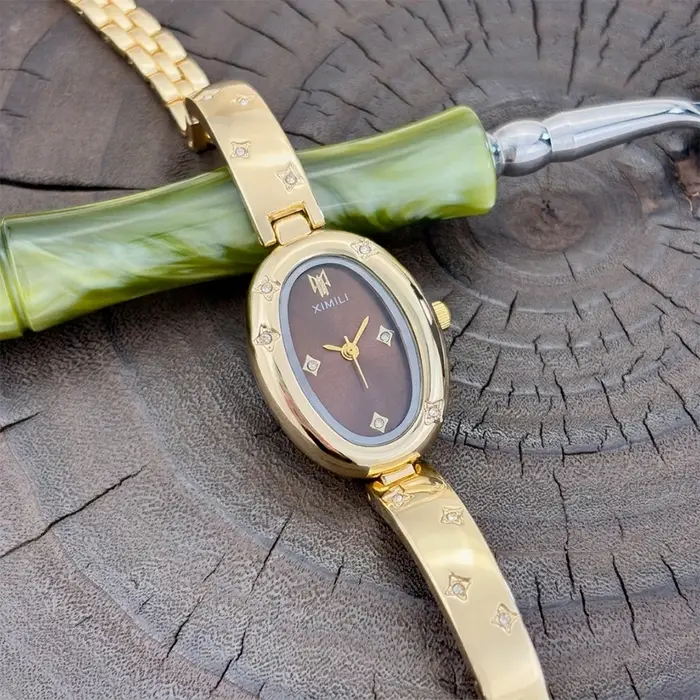 Montre ovale dorée tendance pour femme avec détail gravé en forme d'étoile : un accessoire intemporel