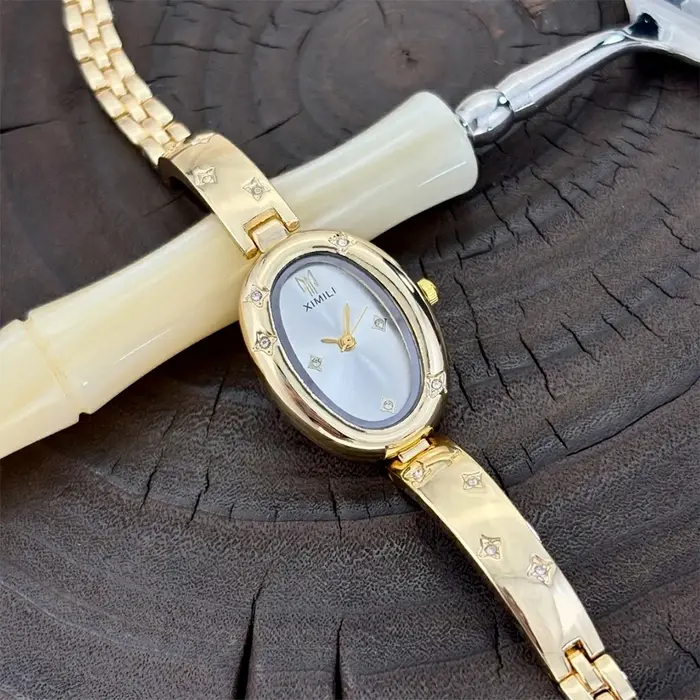 Montre ovale dorée tendance pour femme avec détail gravé en forme d'étoile : un accessoire intemporel